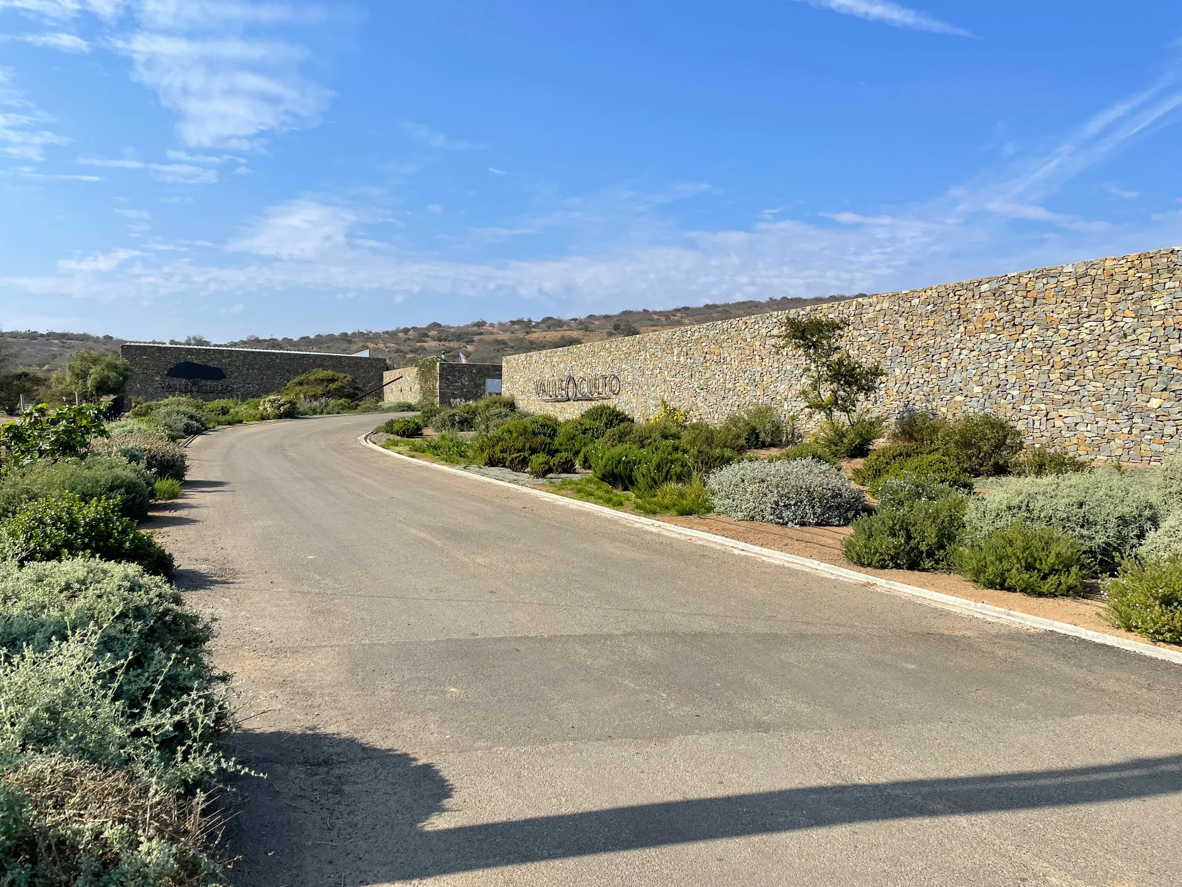 Camino asfaltado junto al muro de piedra